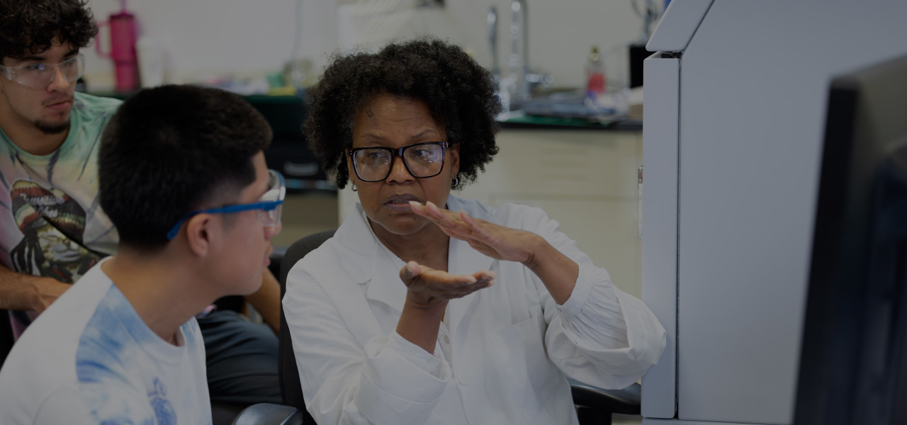 a professor works with a student in a lab