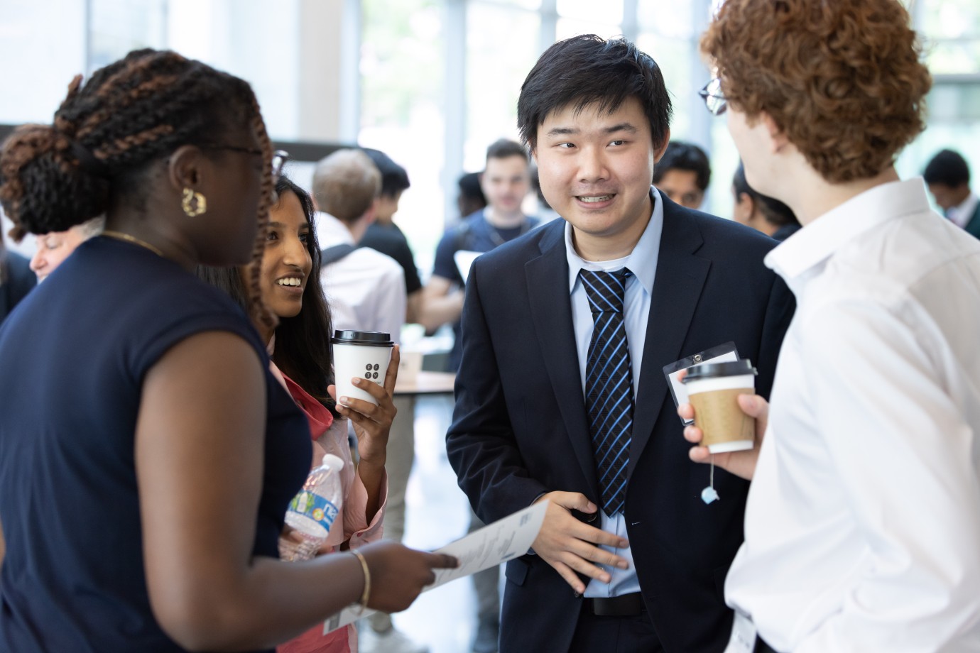 2023 OQI fellows laughing and chatting at the 2023 OQI Research Symposium.