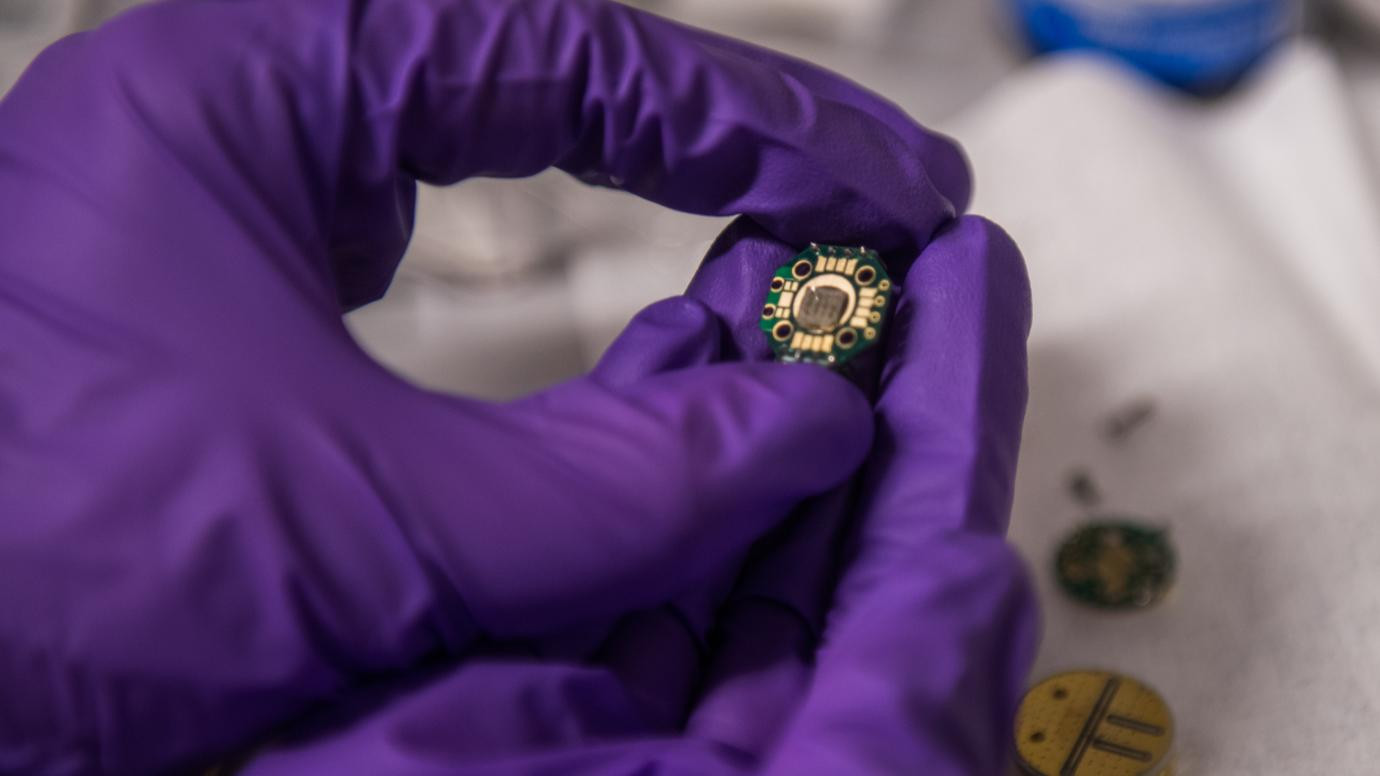 A student holds experimental quantum technology in the laboratory of Prof. David Awschalom at the University of Chicago.
