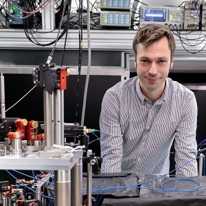 Hannes Bernien in his quantum lab behind an optical table