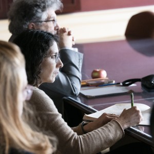 Attendees listen at a conference table
