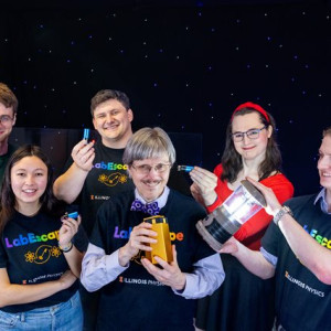 Pictured left to right, LabEscape production team members George Huebner, Danaan Perry, John Benson, Paul Kwiat, Ian Moriarty, and Benjamin Nussbaum pose for a photo as they prepare for the launch of their new mission, &amp;lsquo; Dark Matter Disaster,&amp;rsquo; at Engineering Open House 2026. Photo taken on April 2, 2026 at the Digital Computer Lab in Urbana by Heather Coit, Illinois Grainger Engineering