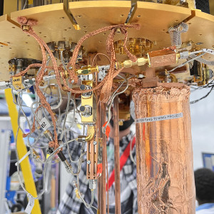 Setup of an experiment at Fermilab to test use of an ultrasensitive detector to search for evidence of dark photons, a hypothetical particle of dark matter. Housed within a dilution refrigerator kept at cryogenic temperatures, the copper wrapped mu-metal can, at right, contains the detector. Credit: Fang Zhao, Fermilab
