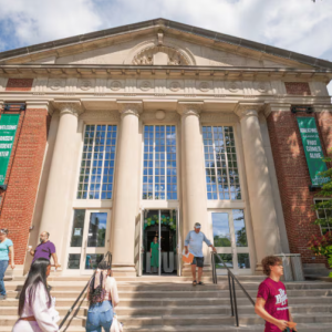 A building on Illinois Wesleyan's campus with students and others walking up and down its front steps