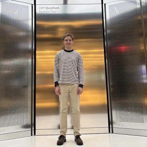 University of Chicago Pritzker School of Molecular PhD student stands in front of the IBM Quantum System Two computer