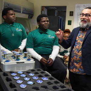 Russell Ceballos, assistant professor, speaks with twin students James, left, and John Kountz about a quantum optics laboratory contained in what is called the Quantenkoffer at the Quantum Education, Science &amp; Technology Center at Chicago State University on Sept. 22, 2026. (Stacey Wescott/Chicago Tribune)