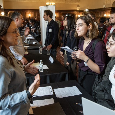 Three women talking over a table at recruiting event